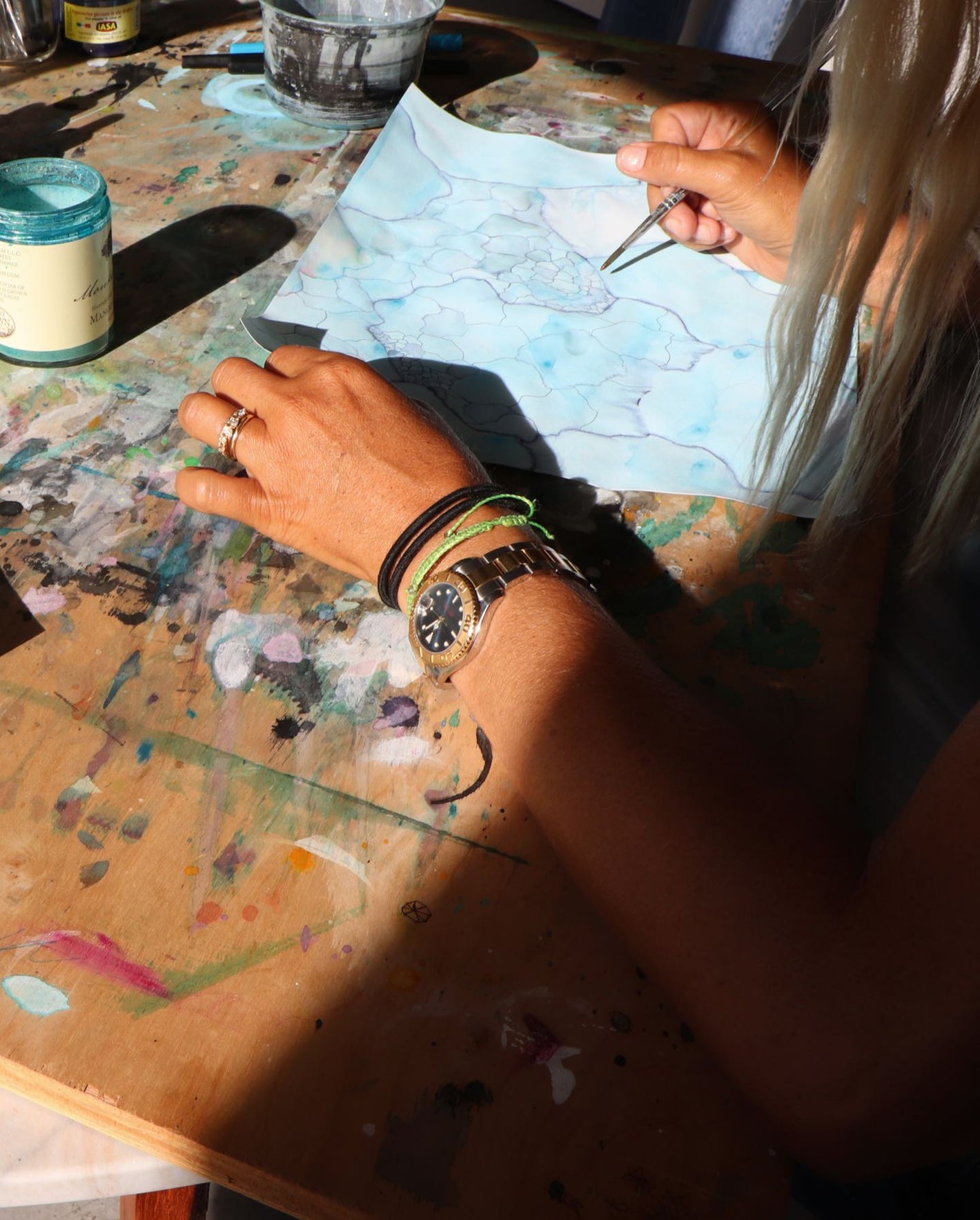 A woman is painting on a wooden table