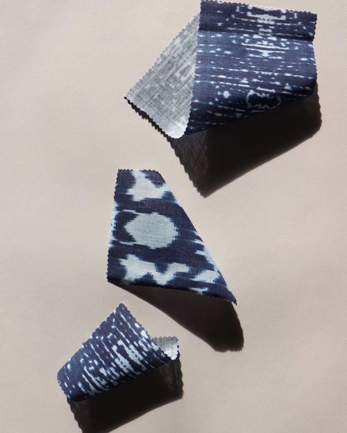 A pair of blue and white fabrics on a white surface