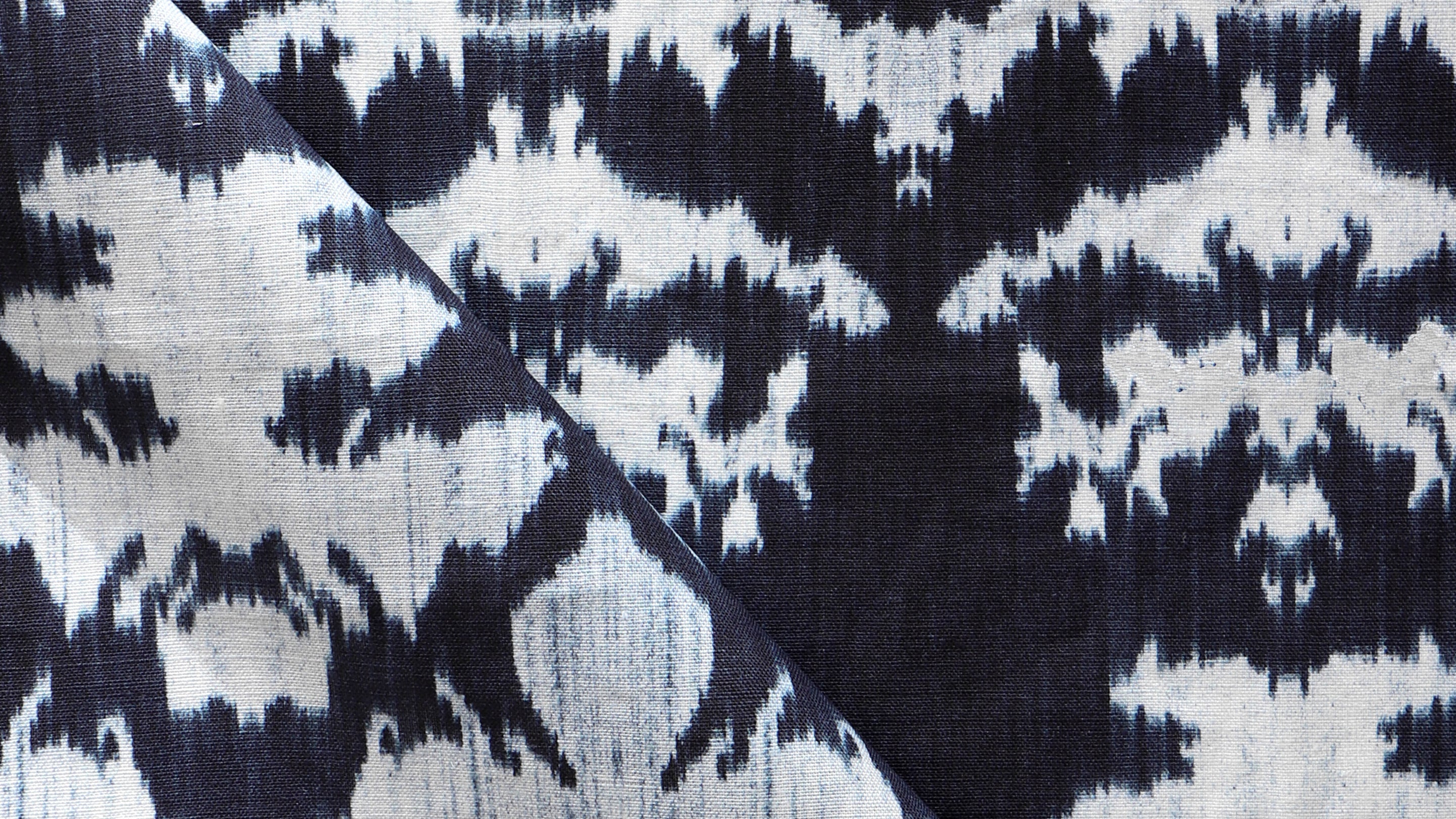 A close up of a blue and white ikat fabric