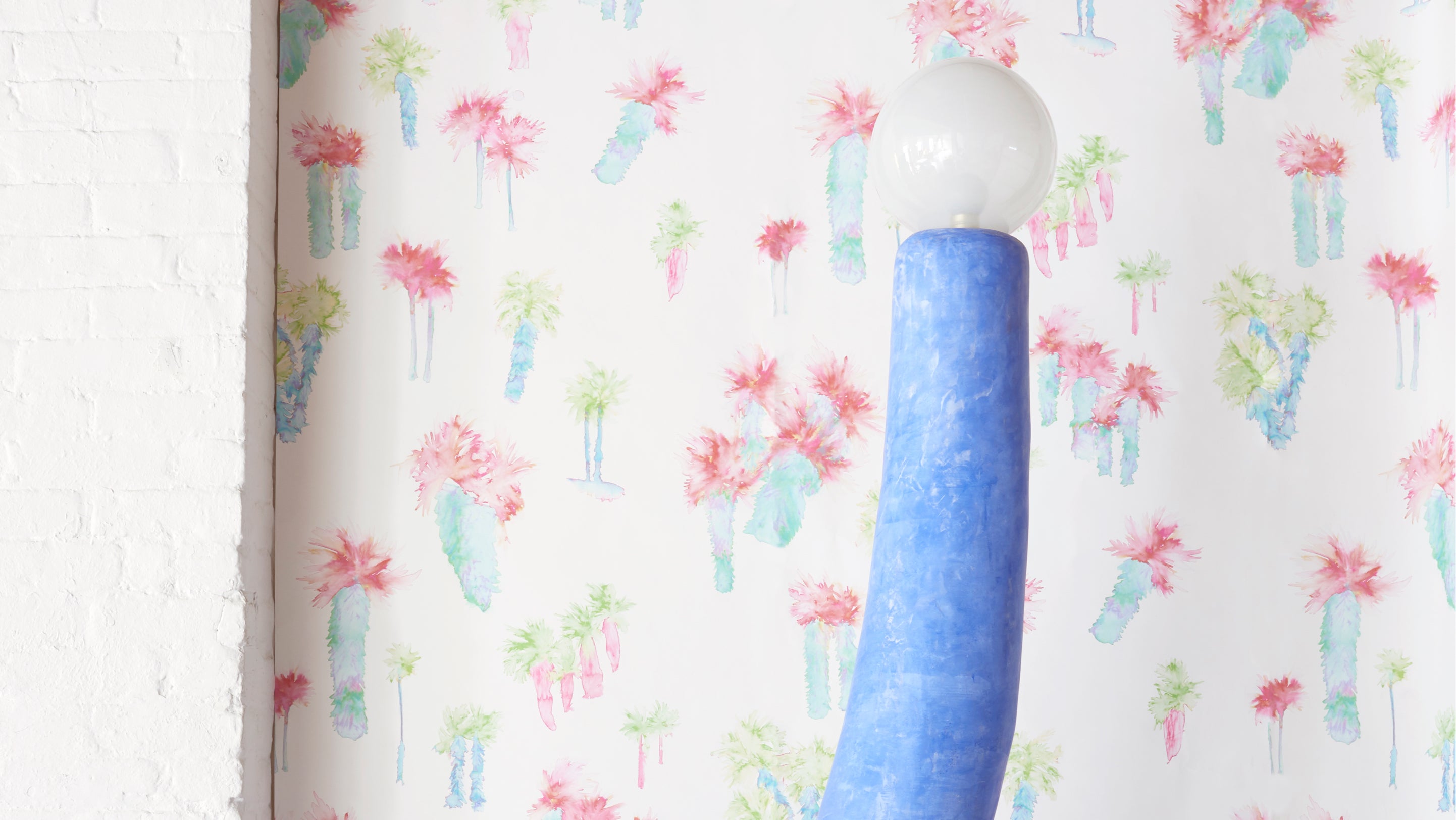 A blue lamp in front of a wallpaper with cactus plants can create a vibrant and soothing ambiance