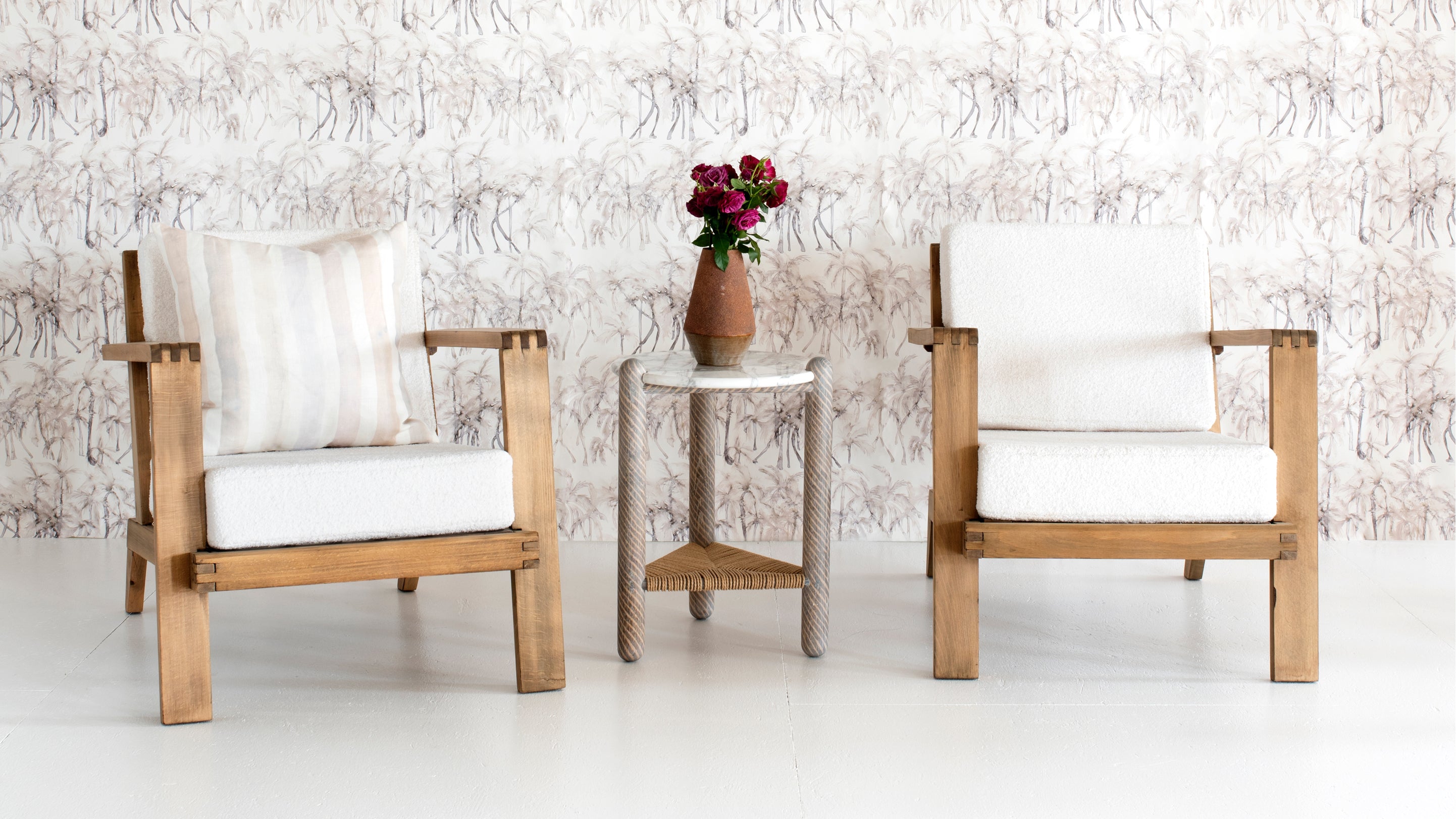 Two chairs and a table in front of wallpaper