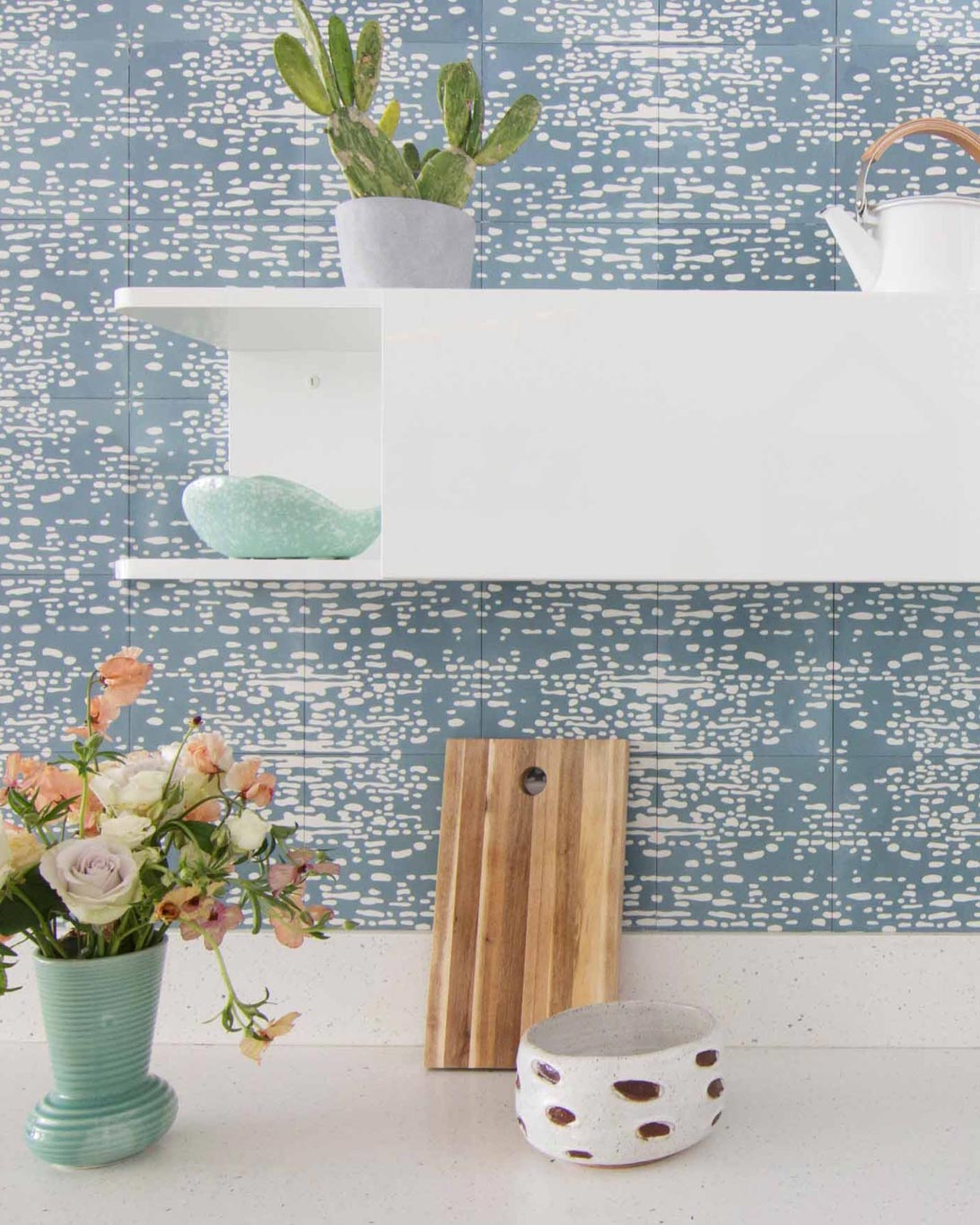 A kitchen with a blue and white tiled wall