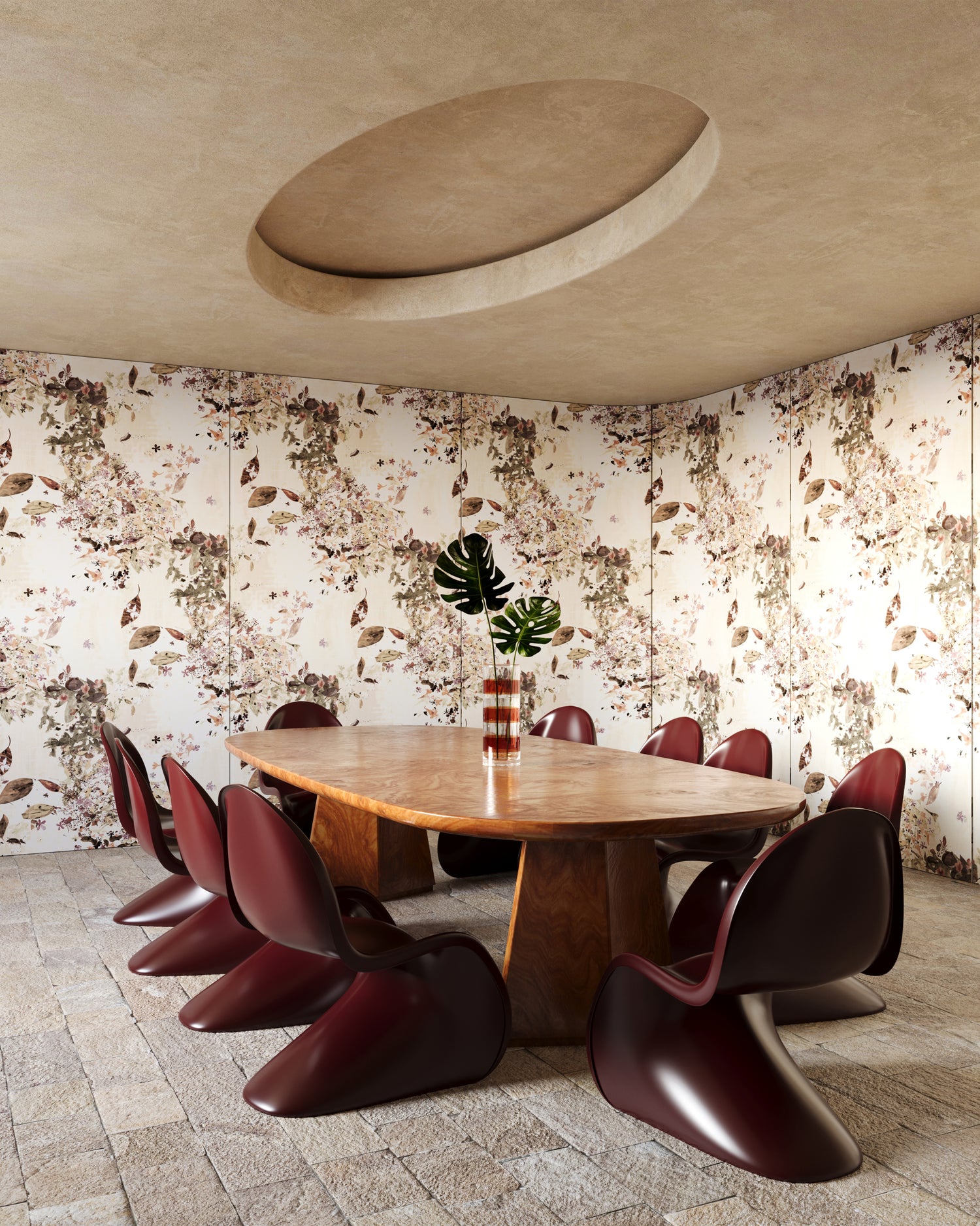 Dining area with a wooden table and modern red chairs against Eskayels Petalos wallpaper in the colorway solar.