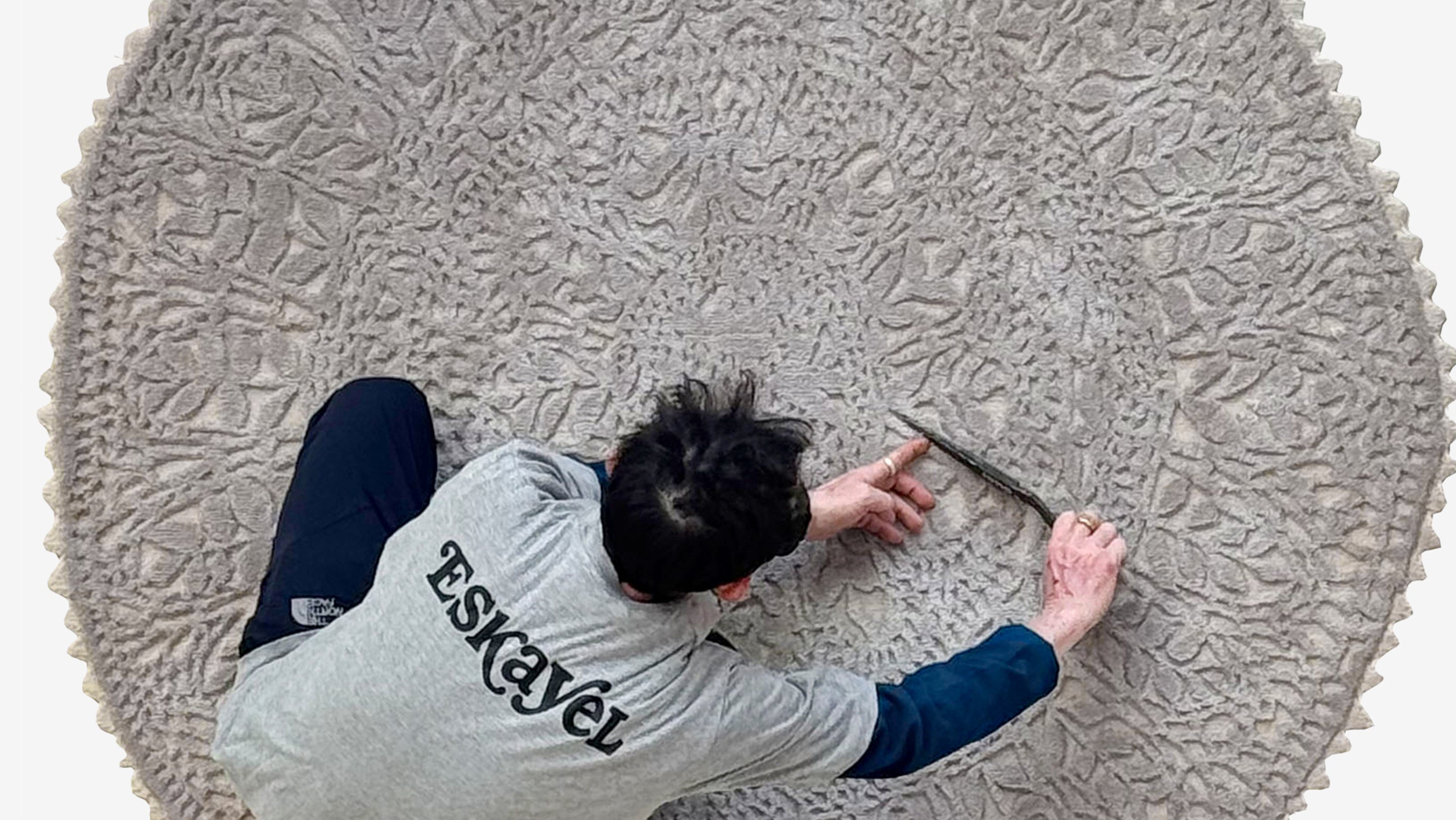 Person working on a textured round rug