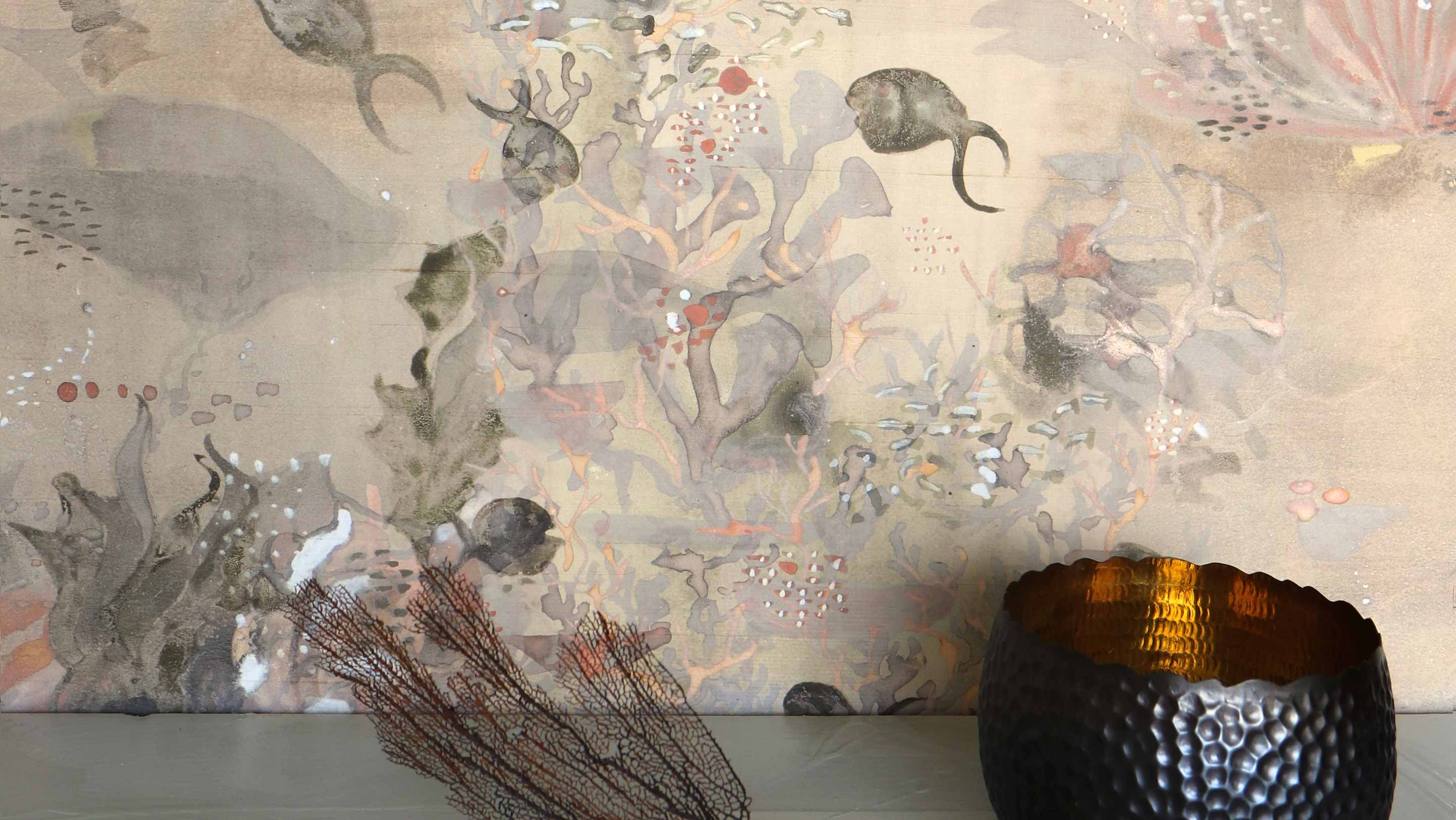 Atoll Sol wallpaper with its beige hue and pops of orange includes fish, coral, and shells. 