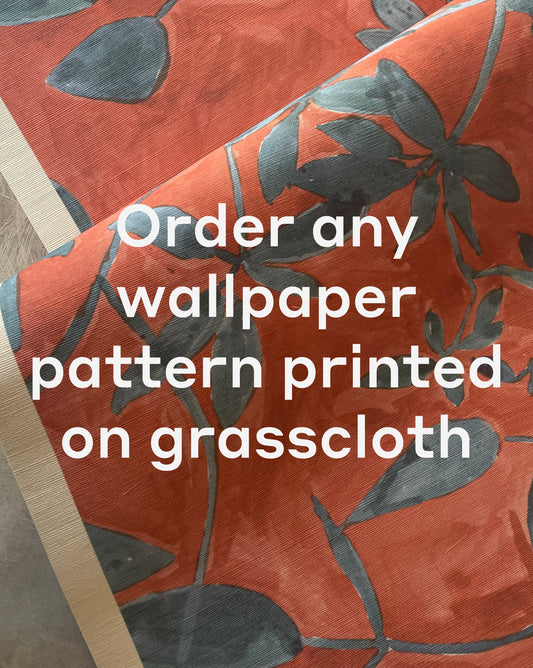 A close-up of Custom Grasscloth wallpaper in red with a blue floral pattern and white text stating, "Order any wallpaper pattern printed on grasscloth.