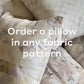 Custom Pillow products featuring abstract, checkered, and other fabric patterns are displayed together with the text "Order a Custom Pillow in any fabric pattern" overlaid.
