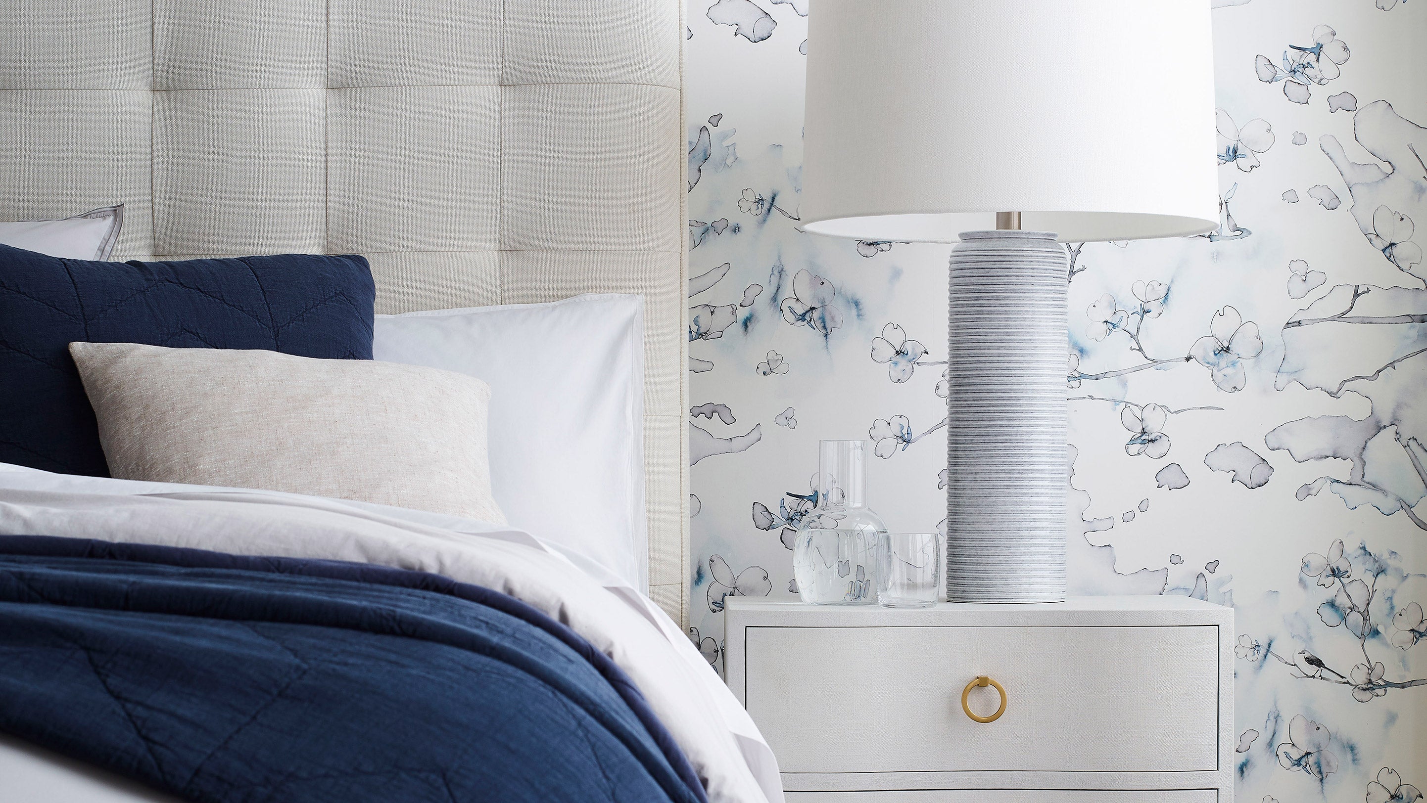 Dogwood dreams Wallpaper in indigo with its navy blue and slight pink accents is installed in a bedroom.