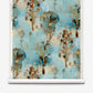 Aionas Grasscloth||Morea wallpaper roll featuring a repeating watercolor-style pattern of brown, stylized trees on a mottled blue, earthy palette background with organic shapes.