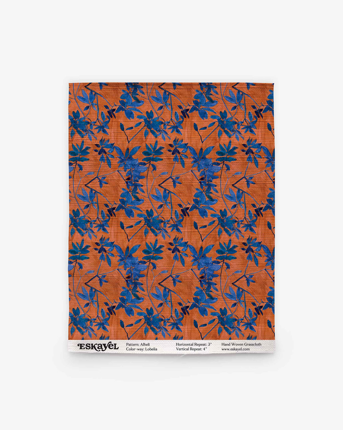 A rectangular swatch of Alhelí Grasscloth in Lobelia, an orange hand-woven wallpaper featuring a pattern of blue botanical silhouettes.