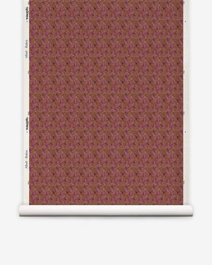 A roll of Alhelí Grasscloth||Rubra eco-friendly wallpaper featuring a deep brown and magenta floral pattern on a textured background.