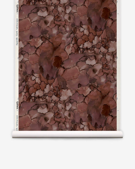 Aquarelle Grasscloth||Earth wallpaper roll featuring an abstract, watercolor-inspired marbled pattern in shades of brown, taupe, and dark red.