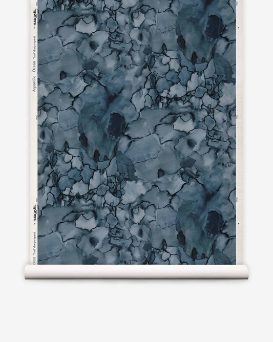 Roll of Aquarelle Grasscloth||Ocean eco-friendly watercolor wallpaper with an abstract blue and grey pattern and a cracked, stone-like texture.