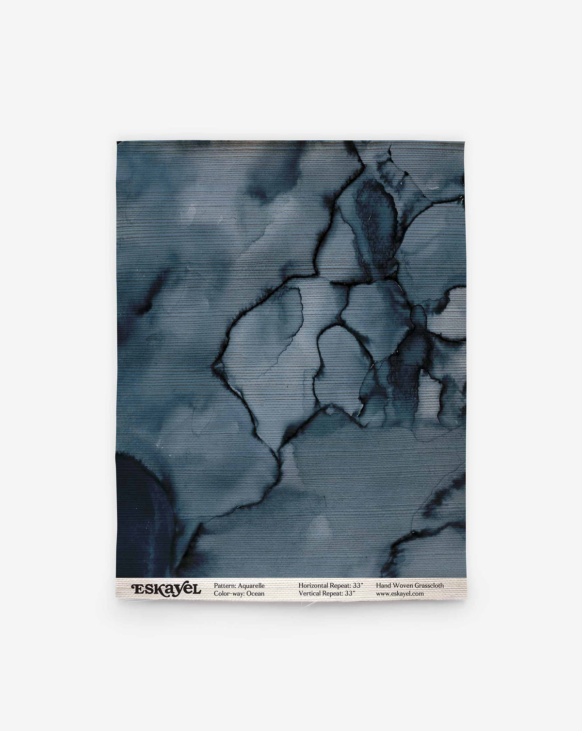 An Aquarelle Grasscloth Sample in Ocean, featuring a dark blue, watercolor-style marbled pattern with product specifications at the bottom and an order button.