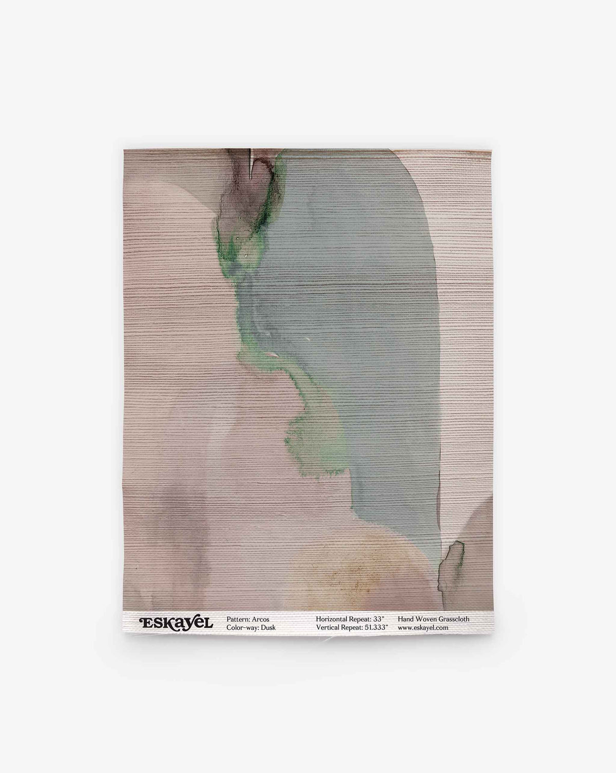 A rectangular Arcos Grasscloth Sample||Dusk fabric swatch featuring abstract watercolor patterns in muted pink, green, and beige tones. The bottom edge displays printed product details and the Eskayel logo on a white strip. Order a sample to experience these unique designs firsthand.