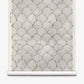Baby Scallop Grasscloth||Dusk: A roll of grasscloth wallpaper with overlapping scallop-shaped geometric motifs on a light gray background.