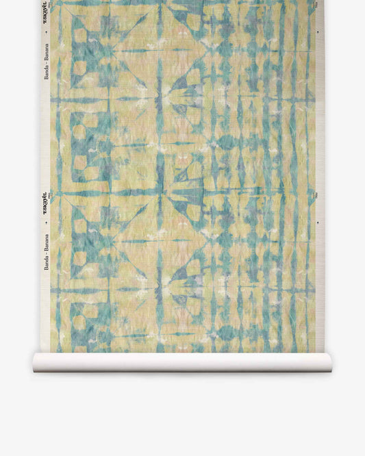A roll of Banda Grasscloth||Banana custom wallpaper is displayed flat against a white background, featuring an abstract blue and yellow geometric pattern.