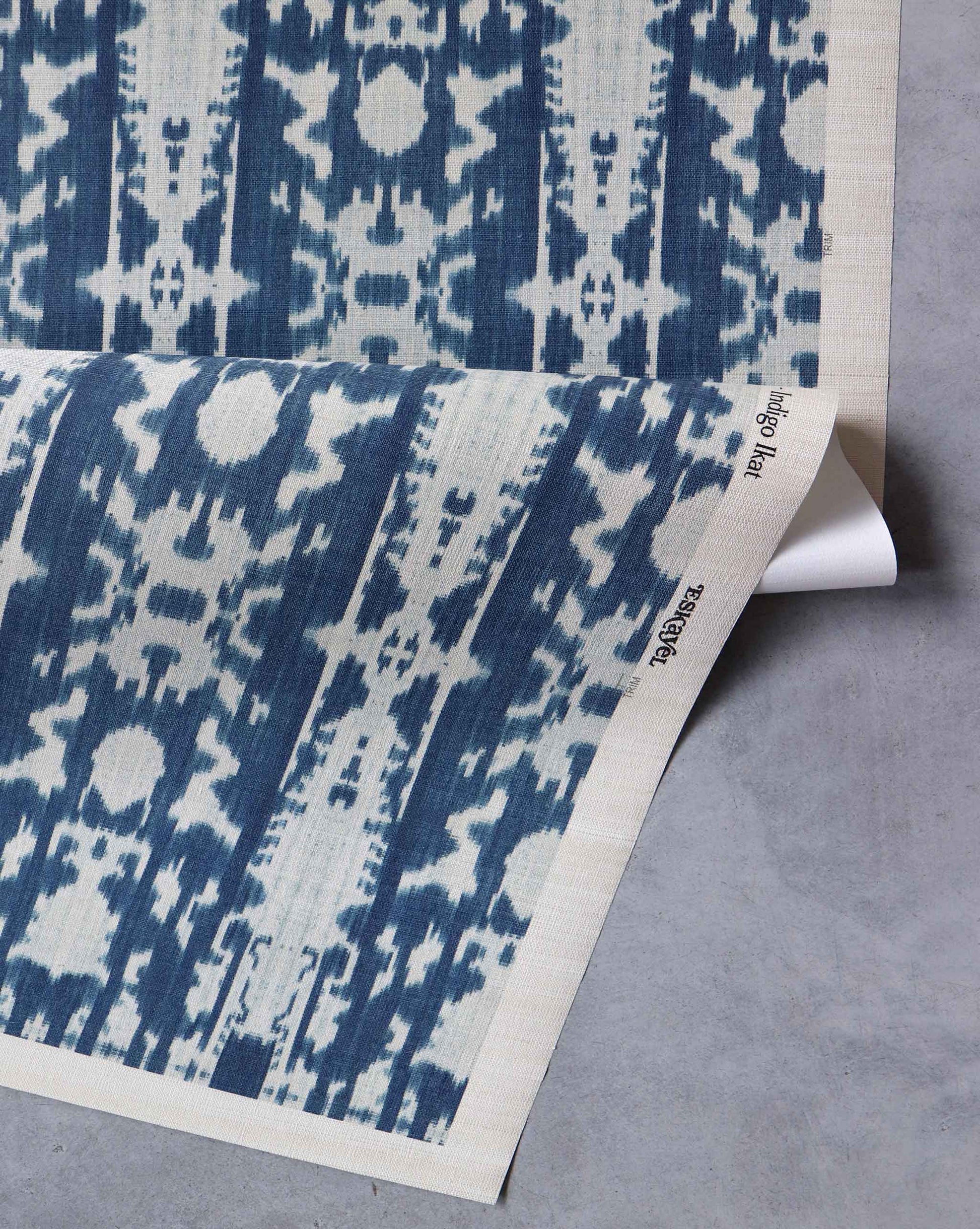 A blue and white Biami Grasscloth Indigo ikat print on a piece of wallpaper