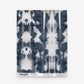 Rectangular fabric sample featuring a symmetrical indigo and white tie-dye pattern, reminiscent of blue-on-white woven textiles. Text at the bottom displays the brand name Eskayel along with details about the pattern, color (Biami Grasscloth||Nila), and website information.