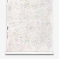 A roll of Bosky Toile Grasscloth in Cay, featuring an abstract, light-colored toile pattern in shades of soft green, purple, and gray.