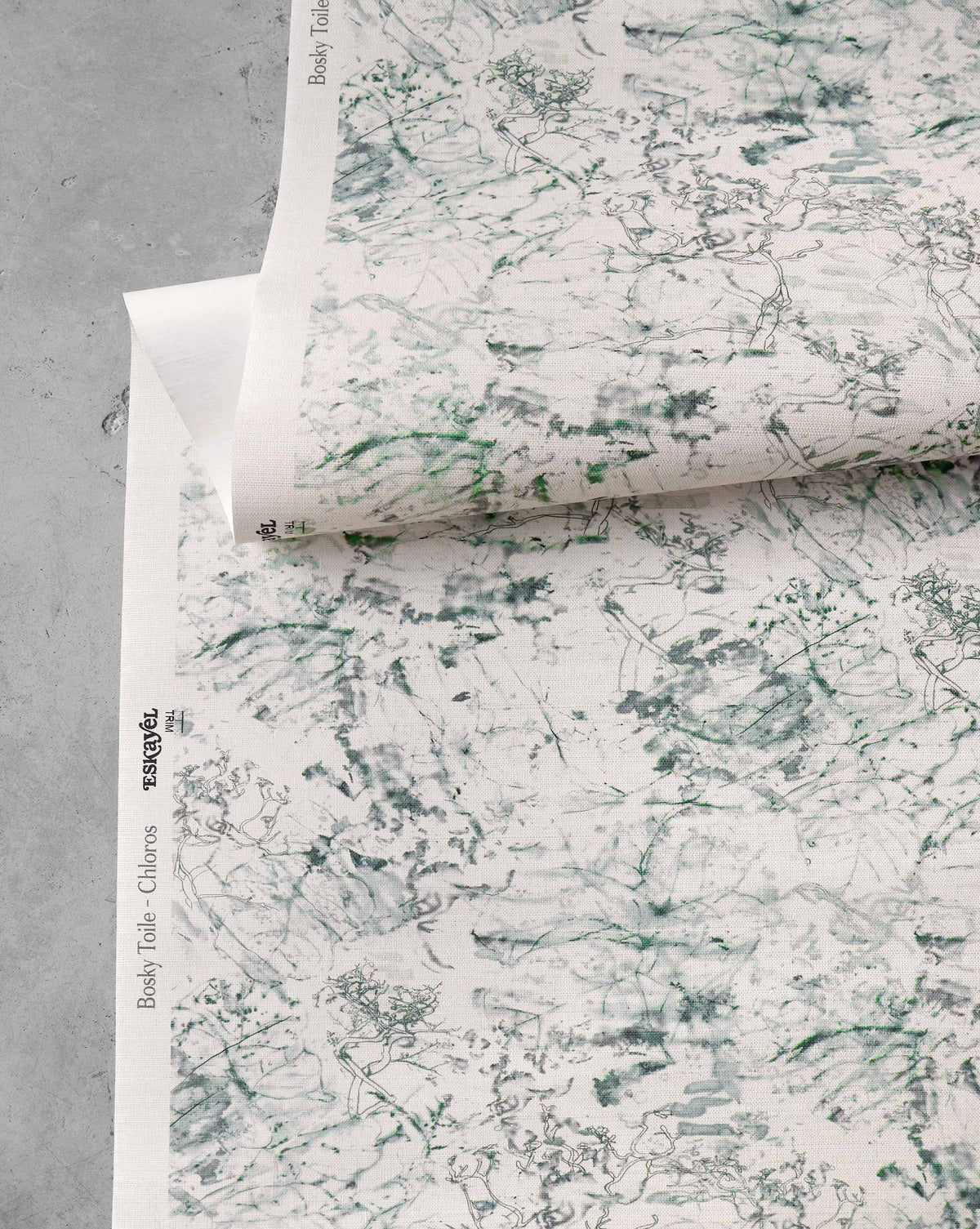 A roll of Bosky Toile Grasscloth in Chloros, featuring a cream-colored luxury sisal background with a green ink sketch of tropical trees and foliage.