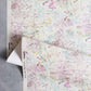 Bosky Toile Grasscloth||Polychrome off-white watercolor wallpaper featuring a multi-colored abstract botanical print in shades of pink, green, and blue.