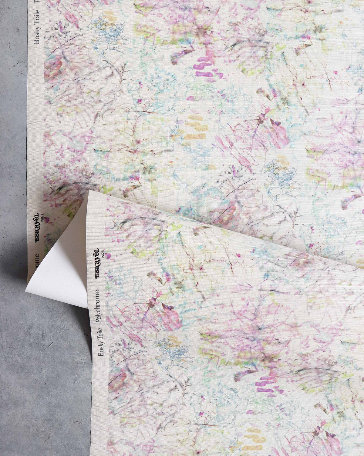 Bosky Toile Grasscloth||Polychrome off-white watercolor wallpaper featuring a multi-colored abstract botanical print in shades of pink, green, and blue.