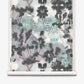 A roll of Clemente Grasscloth in the Canyon colorway from the Presidio Collection, featuring a symmetrical, abstract pattern in black, gray, and hints of blue that evokes ink blots and abstracted trees on a white background—perfect for making a unique statement with custom grasscloth wallpaper.