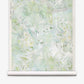 A partially unrolled roll of Cortile Grasscloth||Luminosa wallpaper, featuring a pastel green and white abstract floral design reminiscent of delicate watercolor, displayed against a white background.