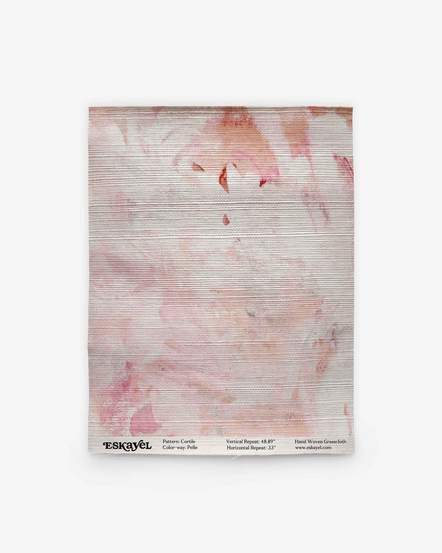 A folded fabric square featuring the Cortile Grasscloth Sample||Pelle with a light pink and peach abstract pattern is displayed against a white background. Product details and the brand name “ESKAYEL” appear at the bottom. Order a sample to experience the quality and color firsthand before making your selection.