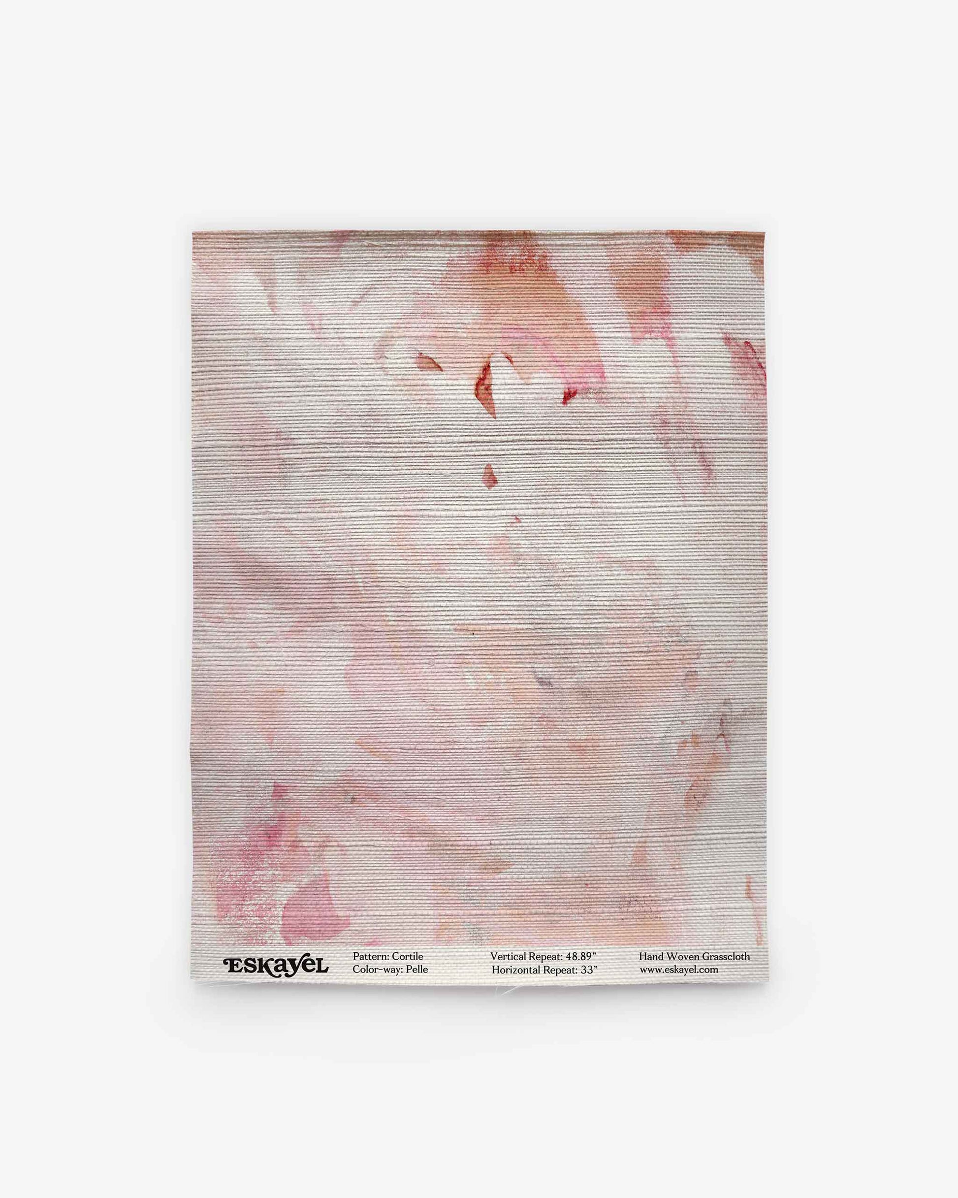 A folded fabric square featuring the Cortile Grasscloth Sample||Pelle with a light pink and peach abstract pattern is displayed against a white background. Product details and the brand name “ESKAYEL” appear at the bottom. Order a sample to experience the quality and color firsthand before making your selection.