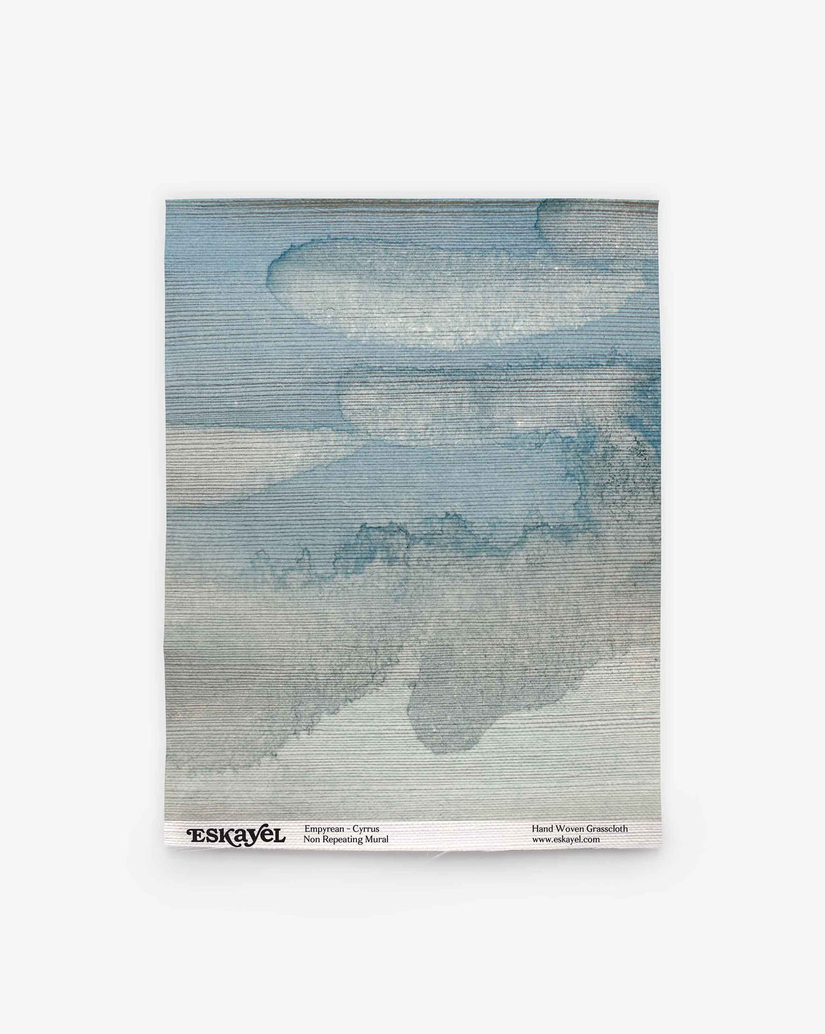 A square swatch of non-woven material featuring a blue and gray cloud-like pattern, labeled “Empyrean Grasscloth Sample||Cyrrus” at the bottom. Order a sample to experience its unique texture and design firsthand.