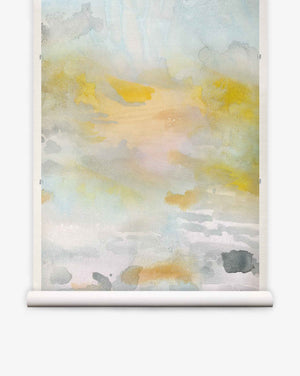 Empyrean Grasscloth Mural Dawn features soft yellow, gray, and blue shades blended in an abstract watercolor style, mounted on a white scroll hanger against a plain background—this piece captures the refined allure of a luxury mural and presents an elegant alternative to traditional watercolor wall coverings.