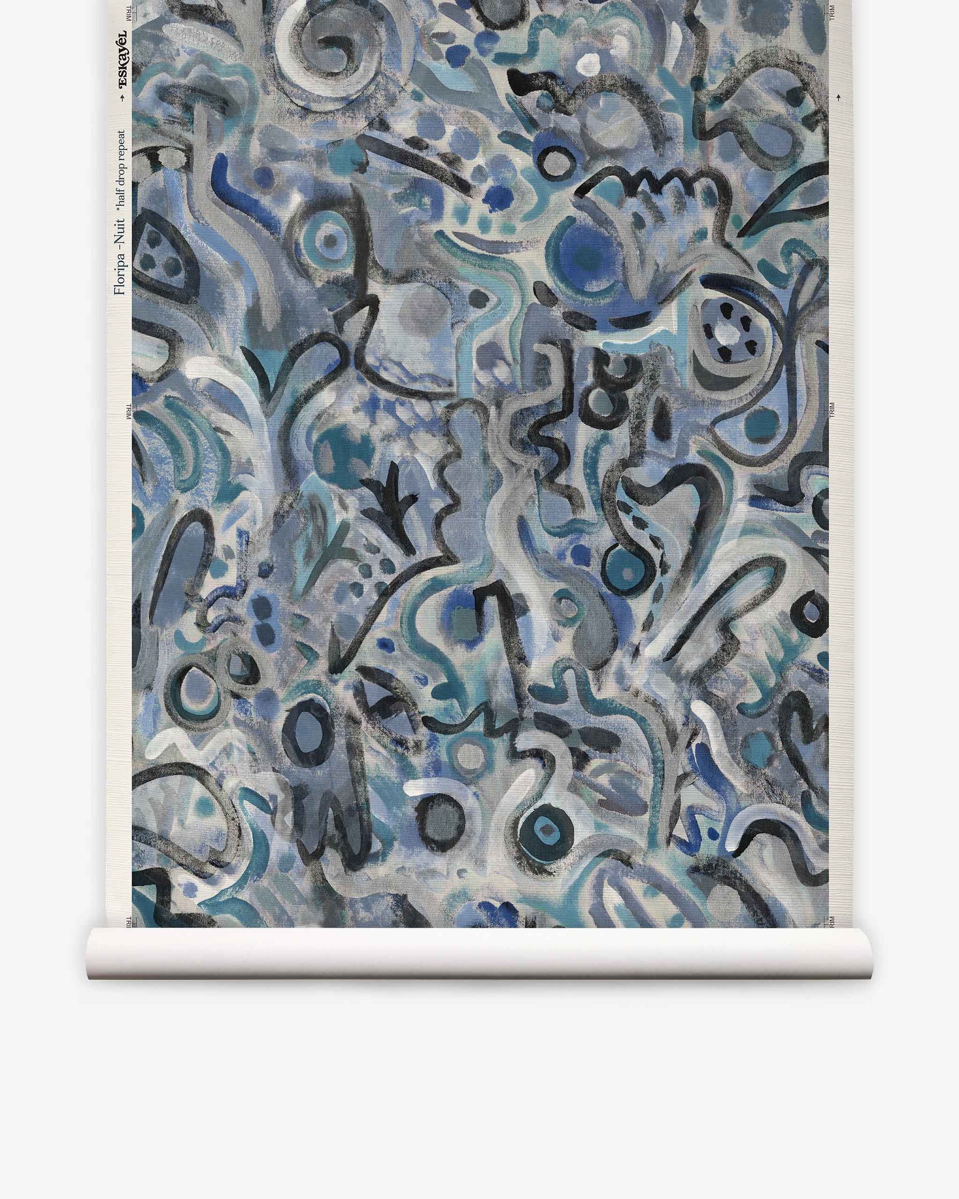 Floripa Grasscloth||Nuit features abstract artwork with swirling blue, gray, and black shapes and lines on a rolled canvas. The chaotic, organic patterns evoke doodles or graffiti, capturing the vibrant spirit of artist collaboration inspired by the dynamic culture of Florianopolis, Brazil.