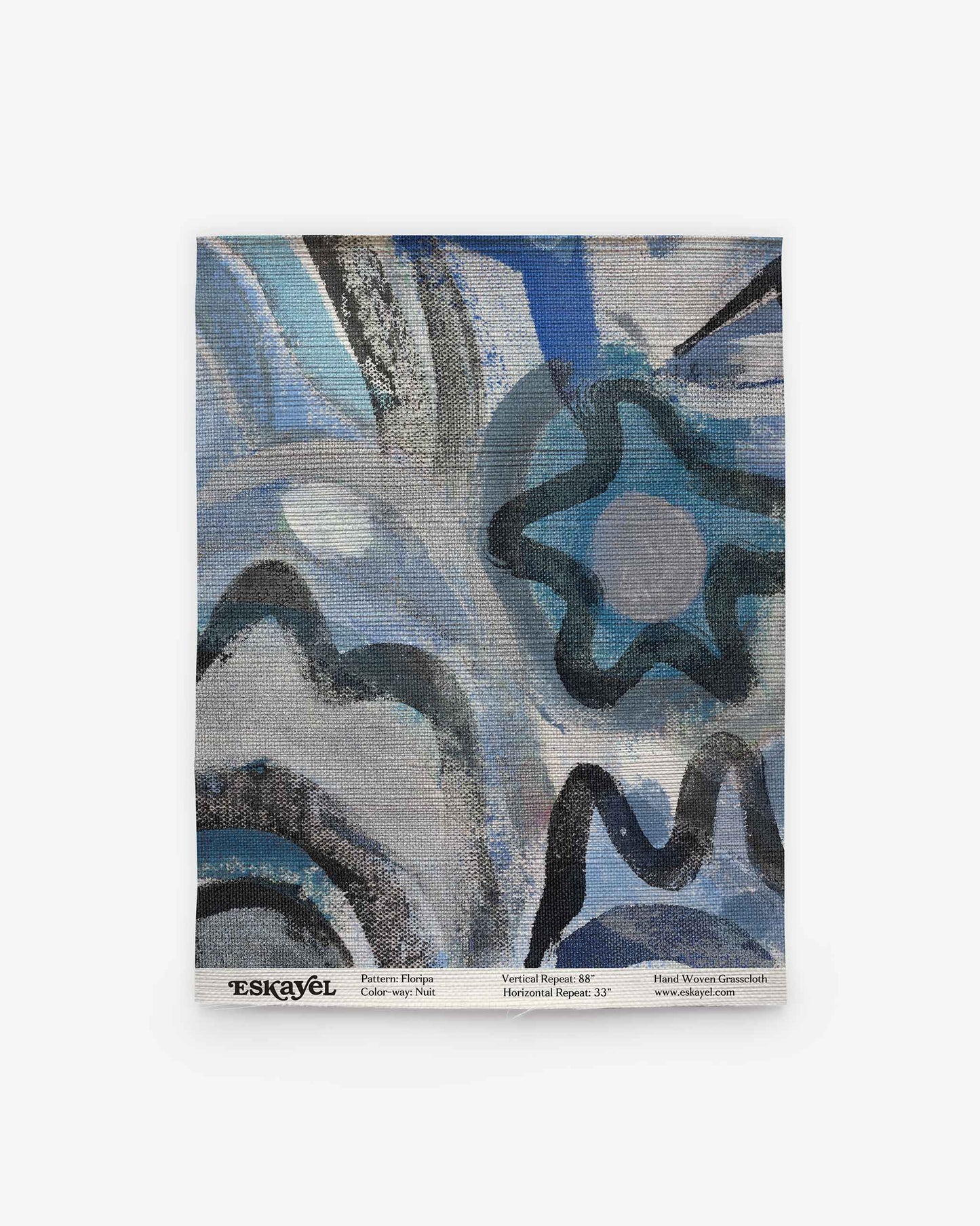 Swirling blue, black, and gray patterns create a star-like motif in the upper right of the textile, evoking the serene landscapes of Florianopolis. Inspired by collaborative artistry, text along the bottom provides background on the piece and partnership. This design reflects the spirit of Floripa Grasscloth||Nuit wallpaper.