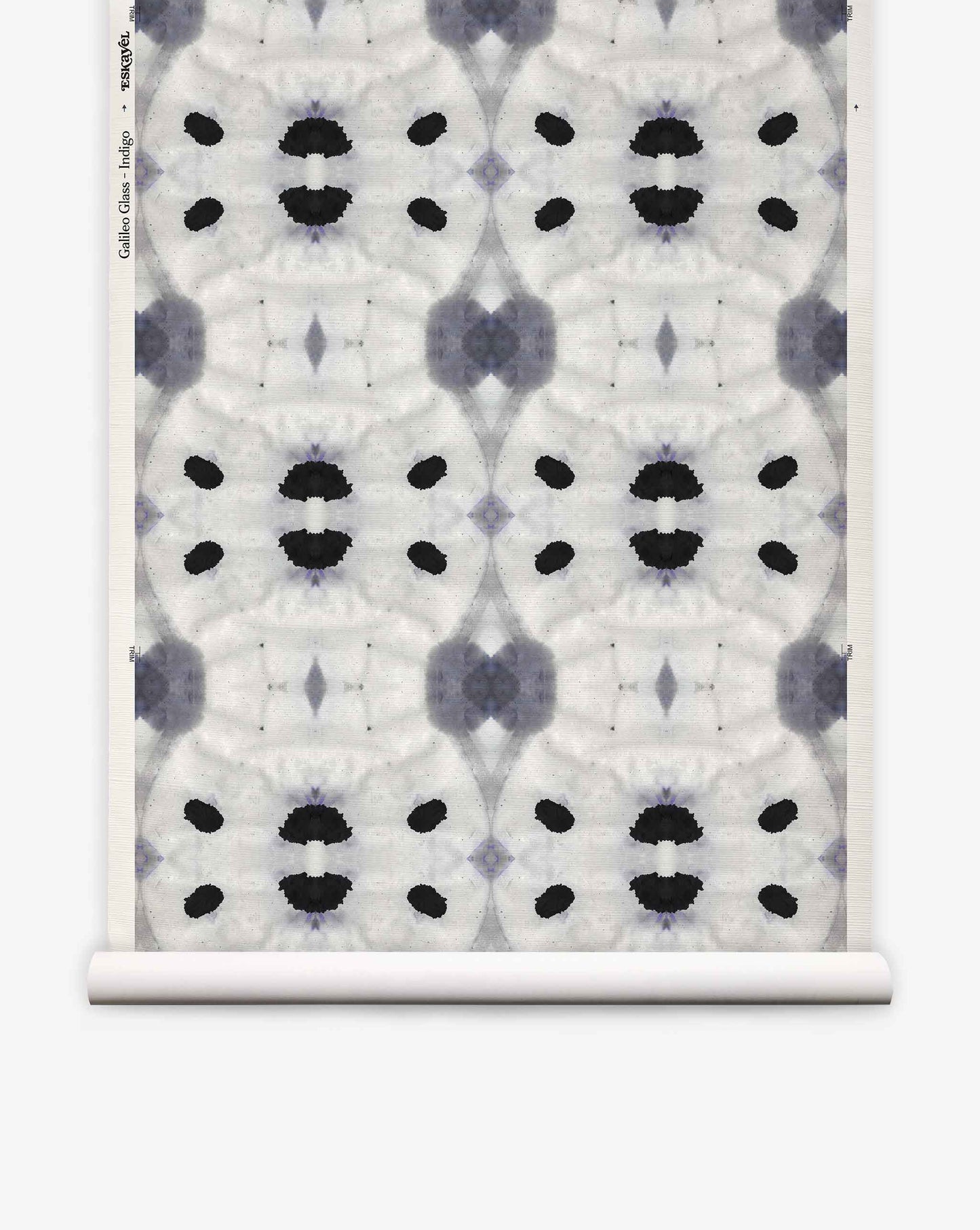 Galileo Glass Grasscloth||Indigo features an abstract black and gray symmetrical pattern reminiscent of ink blots, repeated across a white textured background with a visible paper roll edge. This exquisite wallpaper evokes the refined aesthetic of luxurious grasscloth, lending sophisticated texture and visual intrigue to any interior.