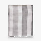 A handwoven textile featuring vertical grey and white stripes, the “Gradient Stripe Grasscloth Sample” in Slate is displayed flat against a white background. Order a sample to experience the quality and detail of this unique design firsthand.