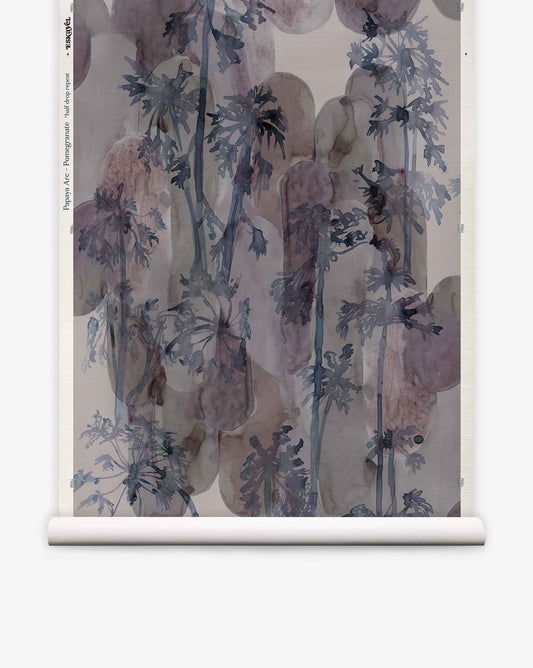 Papaya Arc Grasscloth||Pomegranate hand-painted wallpaper roll featuring a dark blue watercolor pattern of palm-like trees layered over soft, muted red botanical shapes.