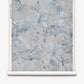 A rolled sheet of Plumeria Shadows Grasscloth||Shadow wallpaper featuring a muted blue and gray floral pattern on a light background, perfect for those seeking a subtle yet elegant tropical wallpaper look.