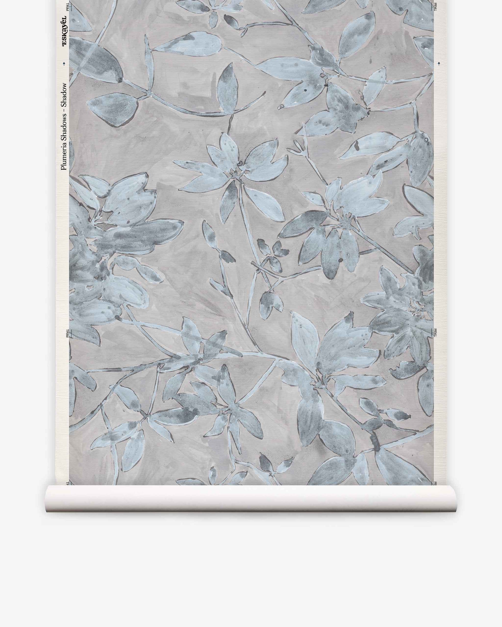 A rolled sheet of Plumeria Shadows Grasscloth||Shadow wallpaper featuring a muted blue and gray floral pattern on a light background, perfect for those seeking a subtle yet elegant tropical wallpaper look.