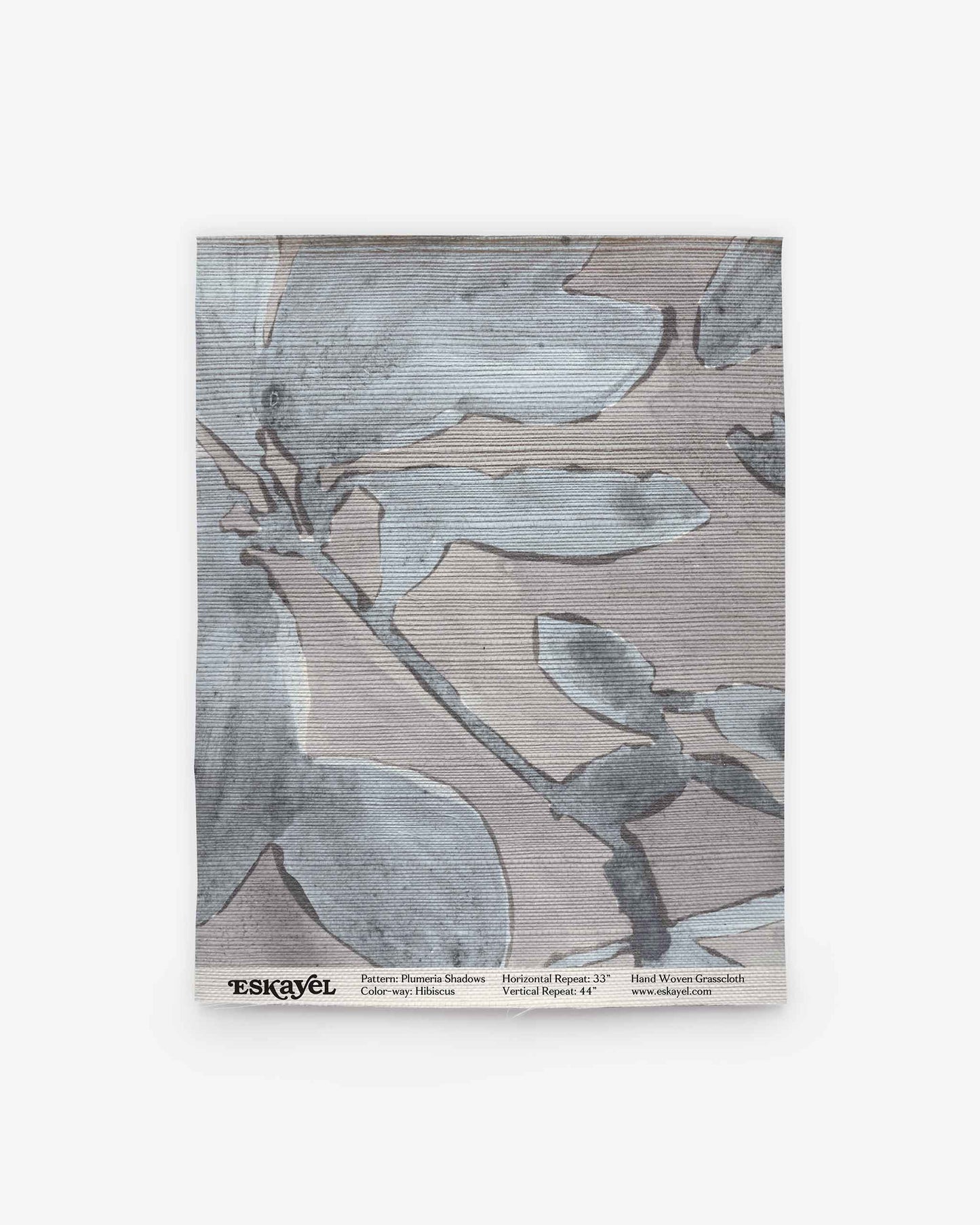 A sample swatch of Plumeria Shadows Grasscloth Sample||Shadow, showcasing a subtle blue and gray abstract leaf design, complete with product and brand details along the bottom. Ideal for discovering new design possibilities—Order a sample today to experience this fabric in person.