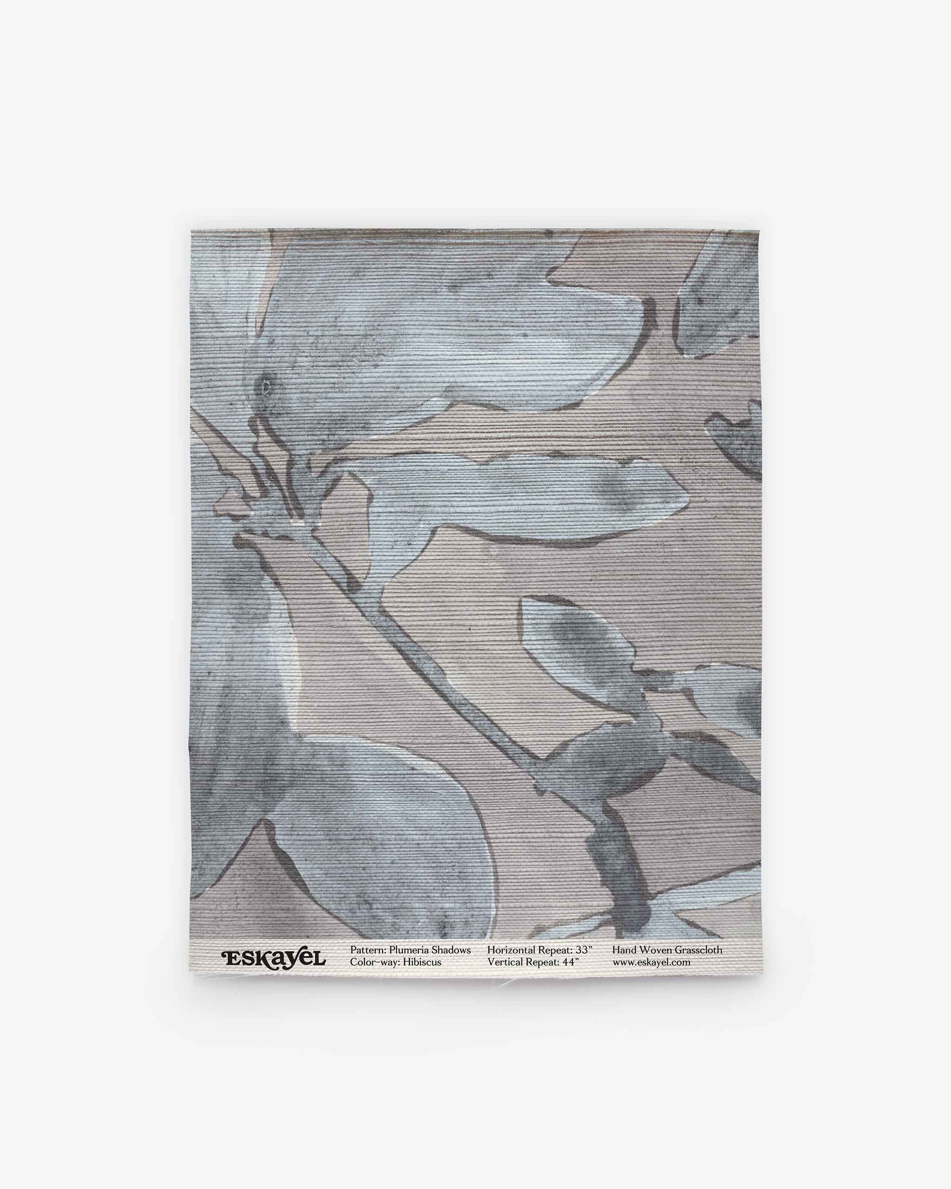 A sample swatch of Plumeria Shadows Grasscloth Sample||Shadow, showcasing a subtle blue and gray abstract leaf design, complete with product and brand details along the bottom. Ideal for discovering new design possibilities—Order a sample today to experience this fabric in person.