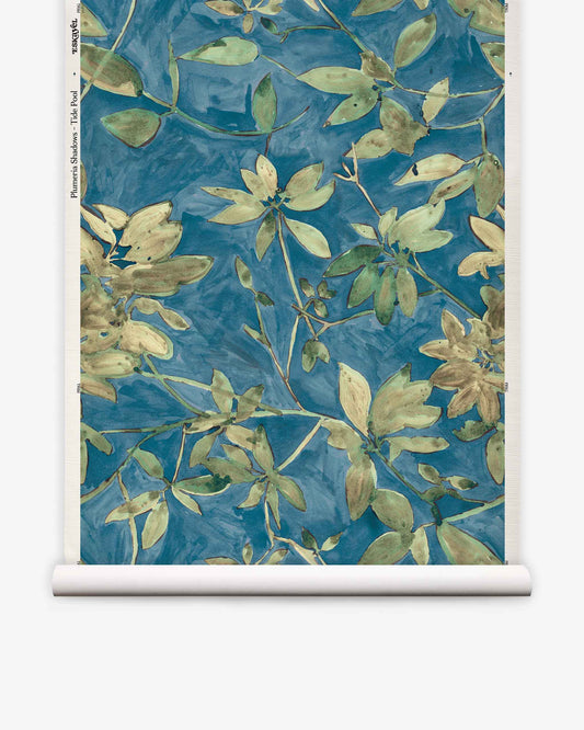 Experience the lush beauty of Plumeria Shadows Grasscloth||Tide Pool—a tropical wallpaper featuring green and yellow botanical patterns on a vivid blue background, shown unrolled in a vertical view. This striking blue grasscloth wallpaper brings vibrant island charm to any space.