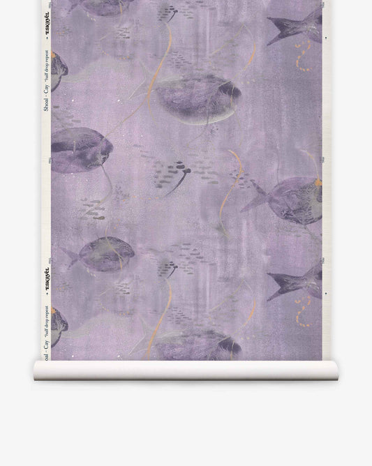 A roll of Shoal Grasscloth||Cay wallpaper featuring a repeating pattern of purple and gray fish swimming among abstract shapes on a lavender background.