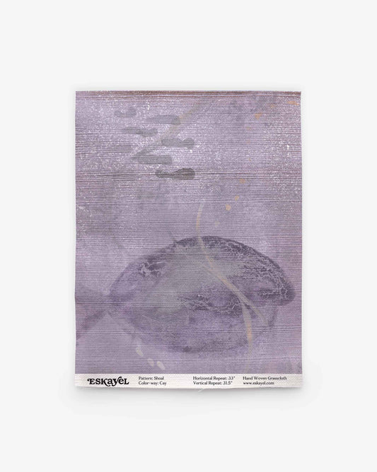 A square fabric sample of Shoal Grasscloth Sample in the Cay colorway, showcasing a muted purple and gray palette with subtle abstract shapes. Text at the bottom lists pattern, color, and dimensions. Order your Shoal Grasscloth Sample today to experience its design and quality firsthand.