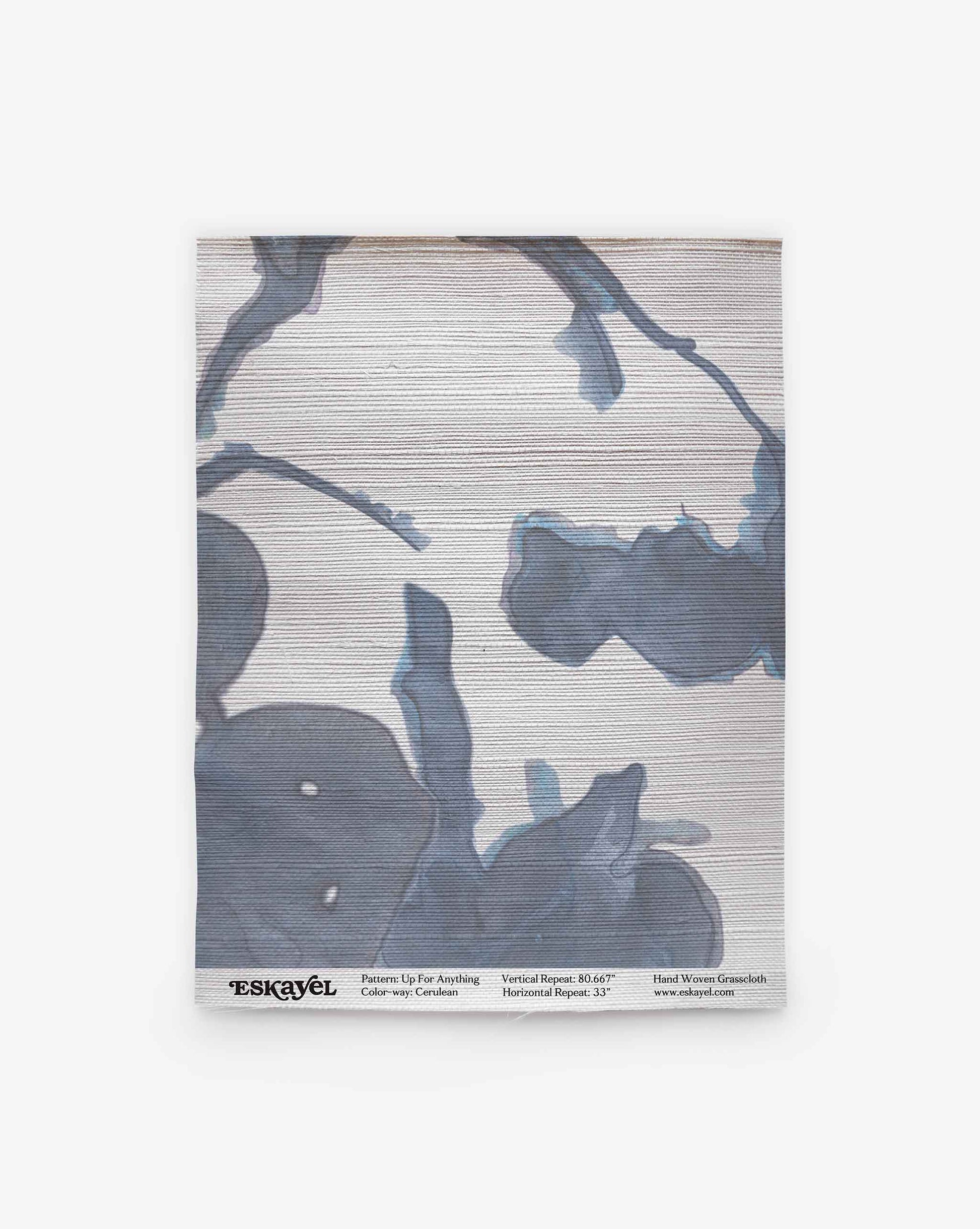 A rolled-up Up for Anything Grasscloth Sample||Cerulean wallpaper sample featuring a blue and gray abstract floral pattern on a light background, displayed vertically with product details along the bottom edge. Order a sample to experience the design and quality firsthand.