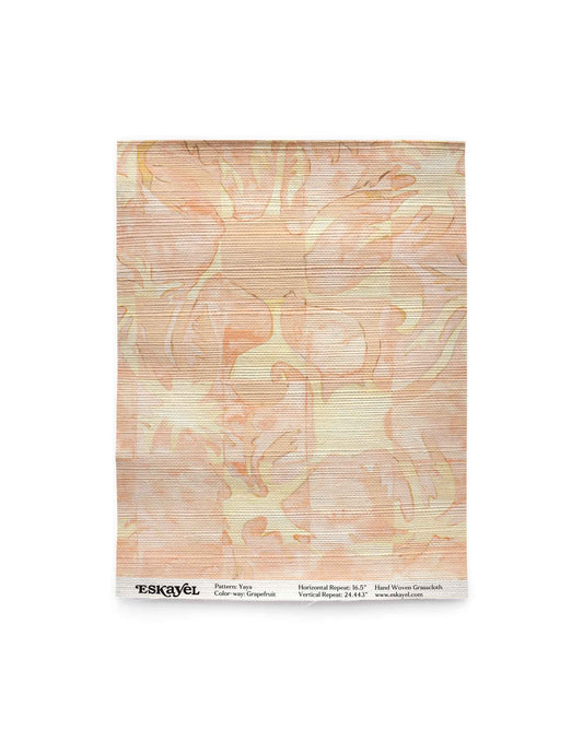 Yaya grasscloth wallpaper in Grapefruit as a swatch — beach-themed graphic botanical wallpaper in pale peach with light yellow highlights | Eskayel