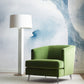 A green chair and lamp in front of a Mod Mural Wallpaper Indigo with abstract design