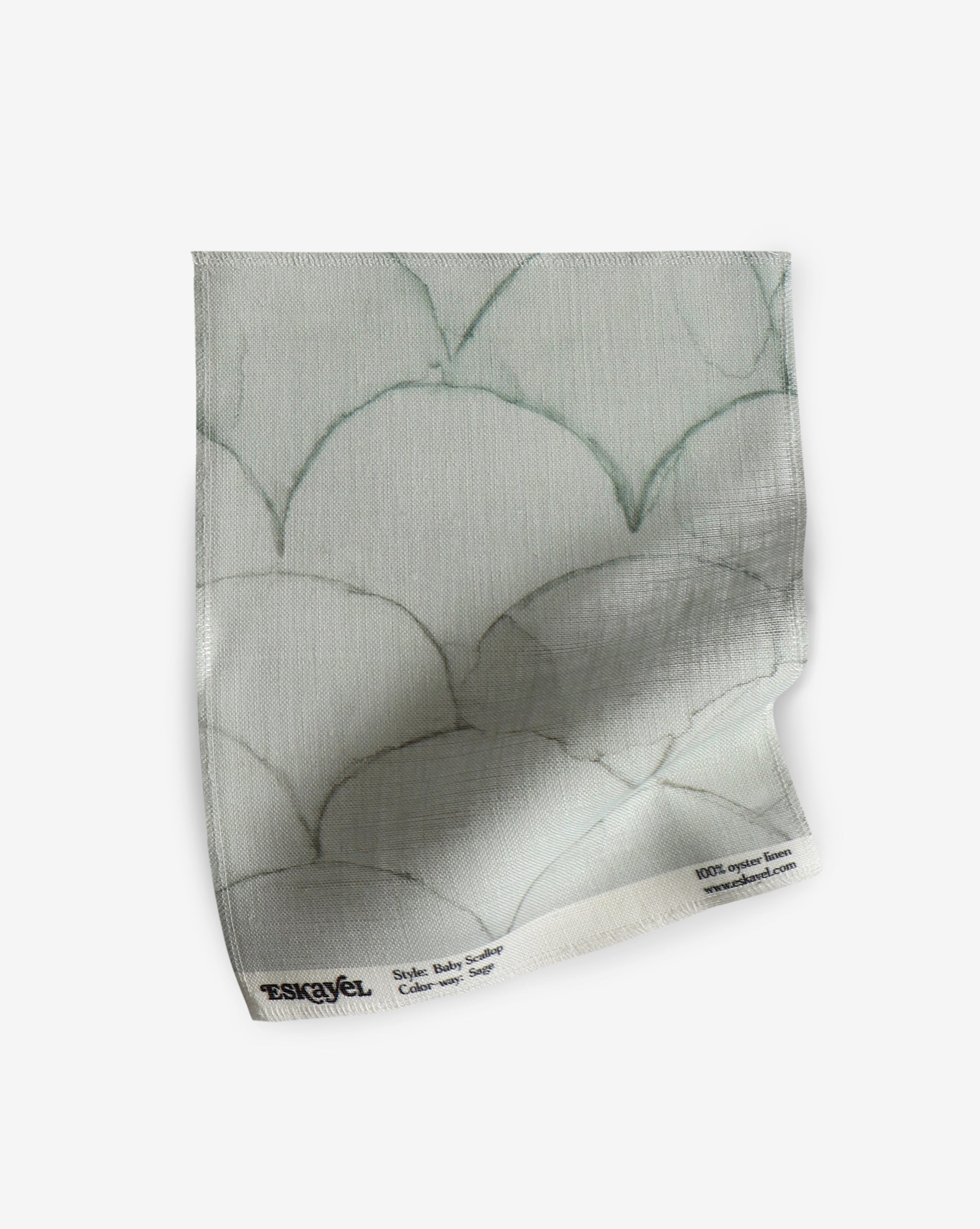 A white fabric with a pattern of Baby Scallop Fabric Sage scales on it