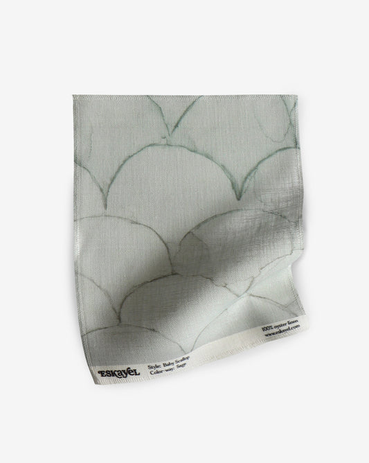 A white fabric with a pattern of baby scallop fabric sample sage scales on it can be ordered as a sample